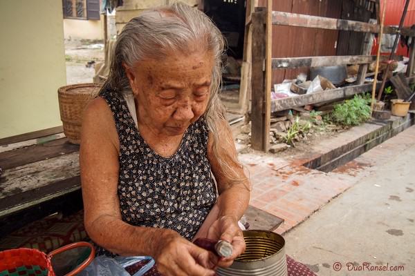Laos - Luang Prabang - Nenek mengupas ubi 